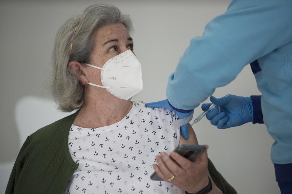 Une infirmière brise un flacon Pfizer et vaccine les patients à la solution saline